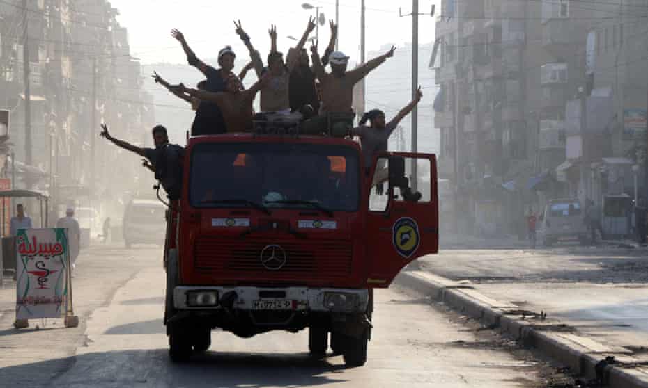 Syrian civil defence volunteers celebrate in Aleppo after the breaking of a three-week government siege.