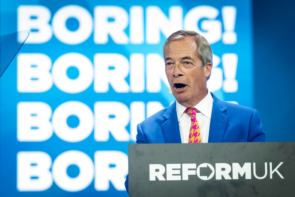 Nigel Farage on stage in front of a sign that says 'Boring! Boring!'