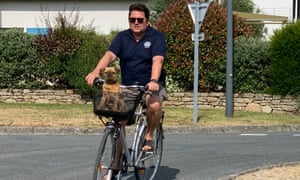 Nicolas Tanguy trên chiếc xe đạp của mình ở Brittany, với con chó trong giỏ
