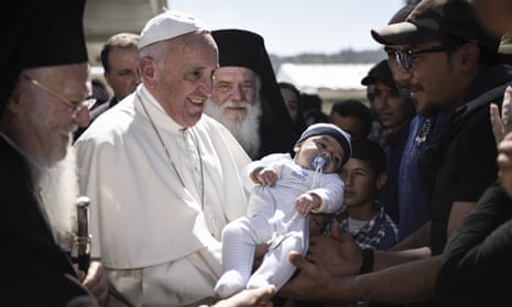 Pope Francis holds a baby at a migration centre in Lesbos