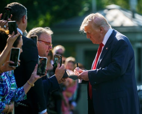 US president Donald Trump signs an autograph for a guest as he leaves the White House, Washington DC, USA.