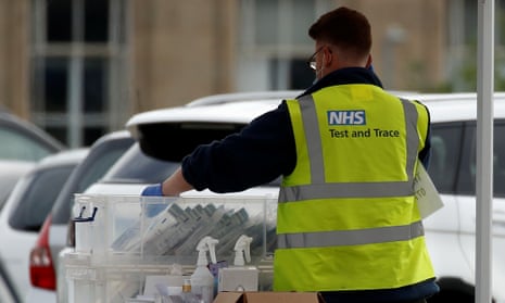 An NHS test and trace worker sorts through coronavirus tests at a drive-through facility in Bolton.
