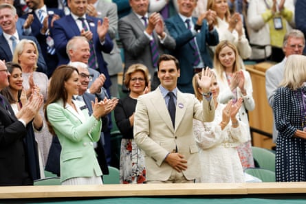 Roger Federer waves from the royal box as he is applauded at Centre Court ahead of play on day two.