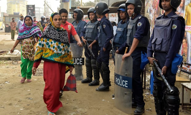 Police stand guard in front of a garments factory in Ashulia