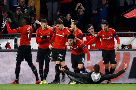 Stade Rennes’ Ismaila Sarr celebrates scoring their third goal with team mates as a pitch invader looks on