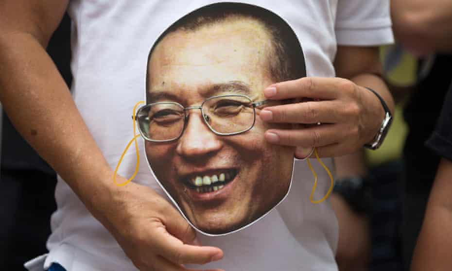 A protester holds a mask of Chinese dissident and Nobel laureate Liu Xiaobo during a protest outside the China Liaison Office in Hong Kong.