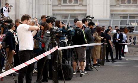 Members of the media work near the site where a car crashed into the front gates of Downing Street in London.