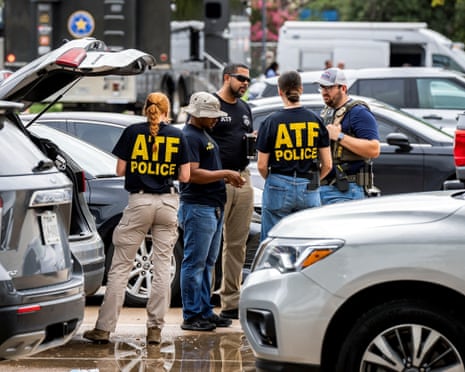 people stand between cars