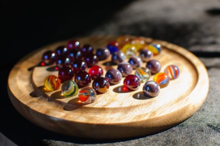 A circular wood board and colorful marbles game of solitaire