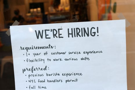 A handwritten hiring sign is seen in a window.
