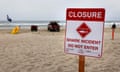 A beach with a 'Closure: shark incident, do not enter' sign