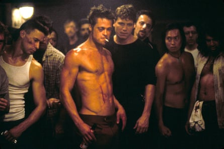 Brad Pitt in Fight Club with no top on, a beer bottle in his hand, and a cigarette in his mouth, surrounded by a crowd of men