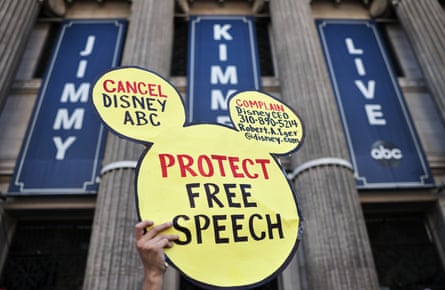 a person holds a sign that reads ‘cancel Disney ABC protect free speech’
