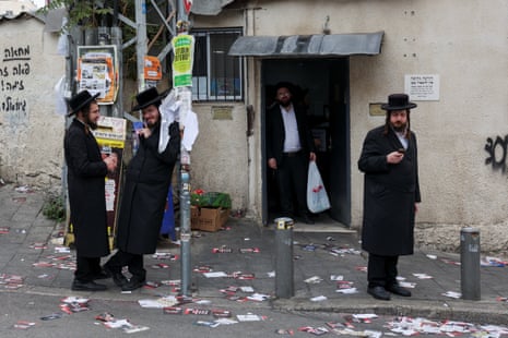 Ultra-Orthodox Jews stand on a street strewn with anti-election pamphlets in the Mea Shearim neighbourhood of Jerusalem