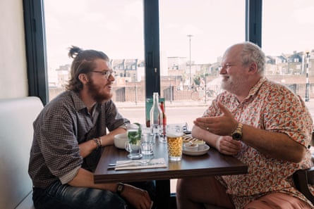 Two men facing each other across a restaurant table