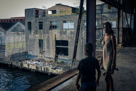 Yurislandi, 8, and Sally, 32, observe the accumulation of waste at the La Coubre shelter in a formerly abandoned port office
