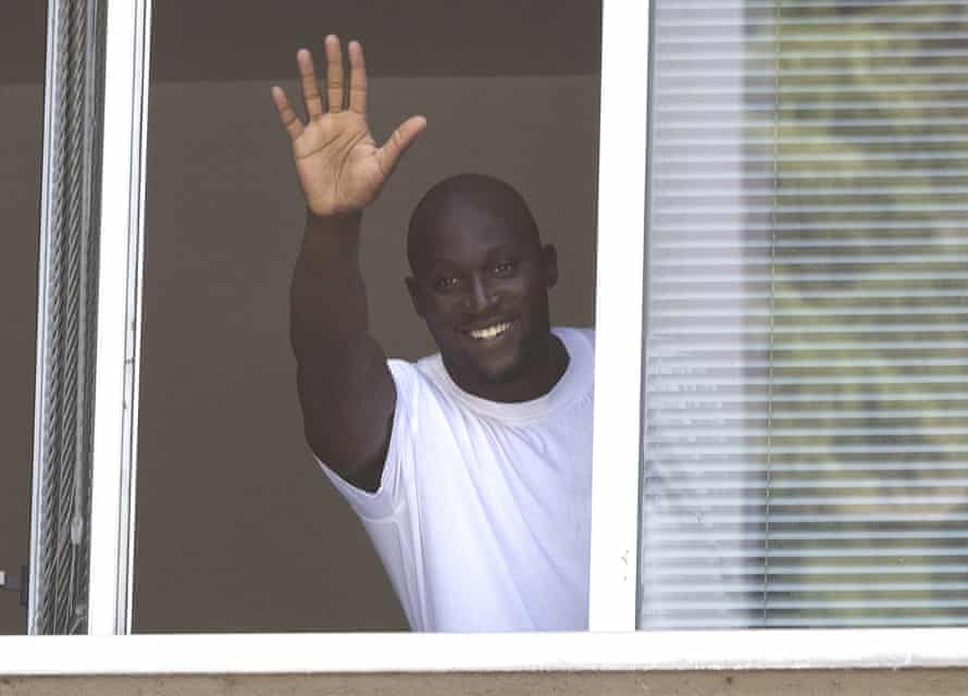 Romelu Lukaku waves to fans in Milan from a window during the transfer window.