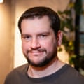 Headshot of dark-haired, bearded man