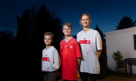 Louis, Vincent and Eliana Hoogenboom wearing red-and-white Switzerland shirts outside at dusk