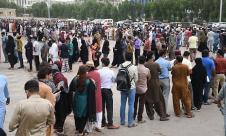 People queue to receive a dose of a Covid vaccine in Karachi, Pakistan.