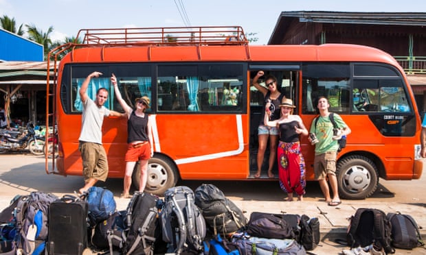 Backpackers wait for their tour bus to depart. Unloading at the last bus stop in southern Laos on the way to Don Det.