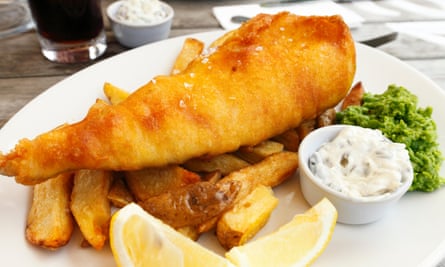 Stock image of restaurant fish and chips with tartar sauce, lemon and mushy peas