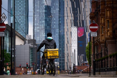 Skyscrapers in St Peter’s Square, Manchester, and a cycle courier with a yellow box on the back