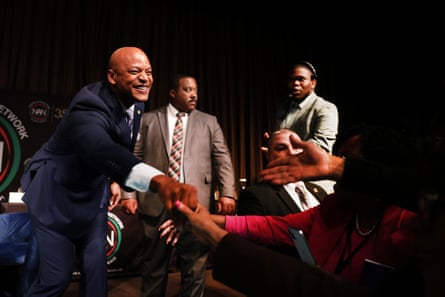 A man reaches ou to shake the hand of an audience member.