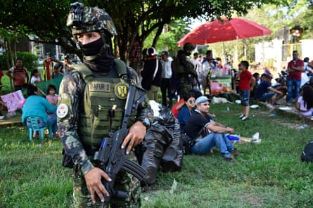 A Colombian soldier guards displaced people in a park in Tibu, Norte de Santander Department, Colombia