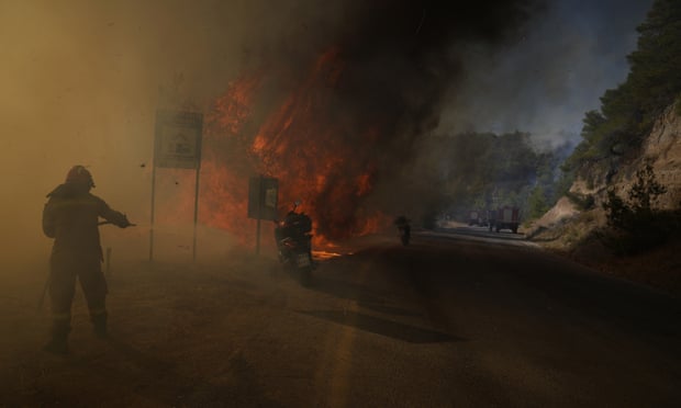 Strażak próbuje ugasić pożar w pobliżu Megary, na zachód od Aten
