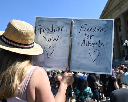 An activist holds a sign outside the Alberta legislature on 3 May 2025.