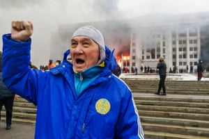 A man rallies outside the burning mayor’s office. Protests are spreading across Kazakhstan over the rising fuel prices; protesters broke into the Almaty mayor’s office and set it on fire.