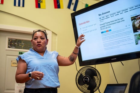 a woman speaks in front of a screen