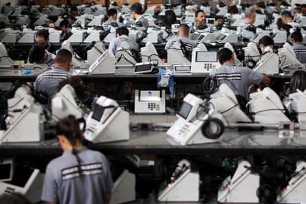 Workers prepare electronic voting machines during a sealing operation before being used in the first round of Brazilian elections.