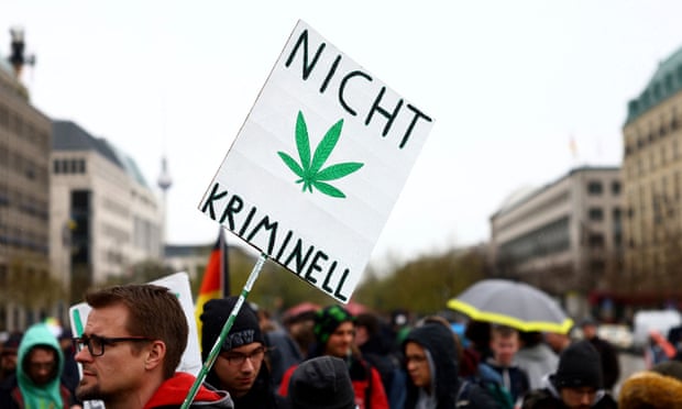 A man carries a sign reading 'Not criminal' in Berlin as he participates in a gathering with marijuana activists