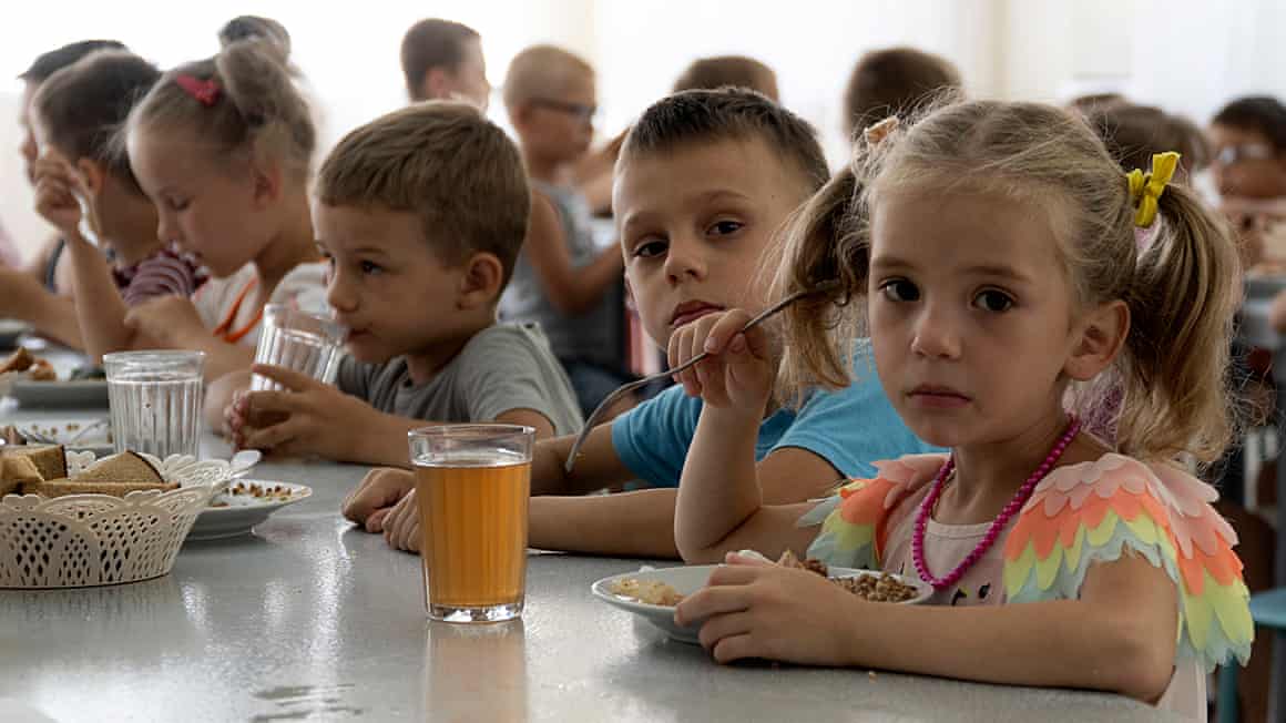 Ukrainian children sitting at tables eating food
