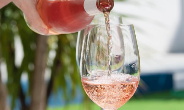 a hand of woman pouring rose wine