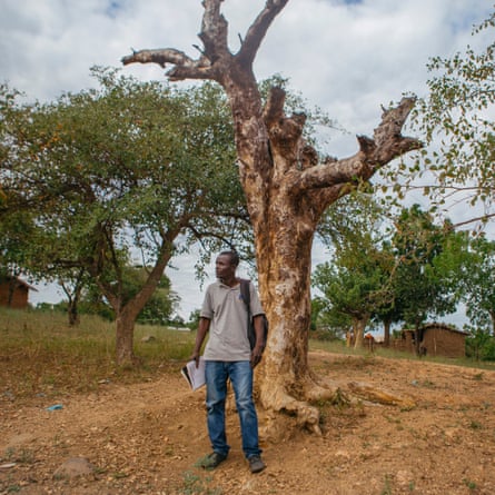 Elson Labu stands by a tree.