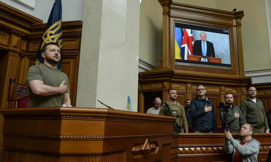 Volodymyr Zelenskiy and members of the Verkhovna Rada stand for Ukraine’s national anthem before the address by Boris Johnson