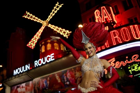 A dancer poses in front of the Moulin Rouge, Paris.