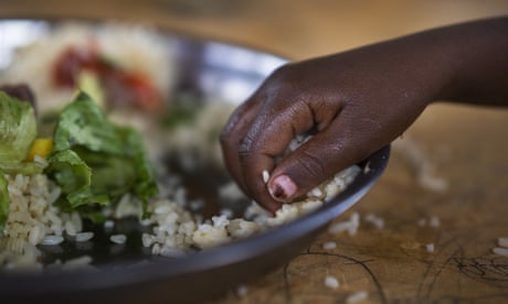 A girl picks food from a bowl in Dollow, Somalia