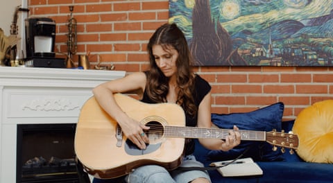 woman playing guitar in a living room