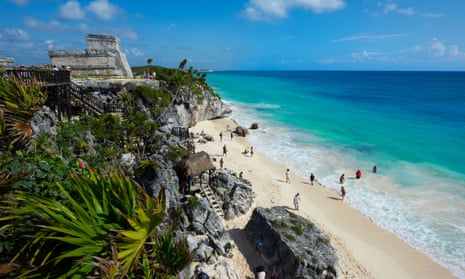 A Mayan temple on a cliff above a beach
