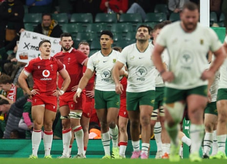 Joe Hawkins and his Wales teammates look dejected after South Africa's Morne van den Berg scores their fourth try.