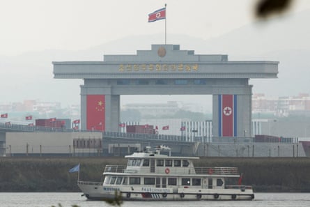 Trucks adorned with Chinese flags cross the newly opened New Yalu River Bridge into North Korea’s Sinuiju