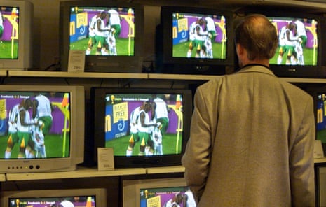 A man watches Senegal's celebrations against France on a wall of TV screens in a department store in downtown Hamburg