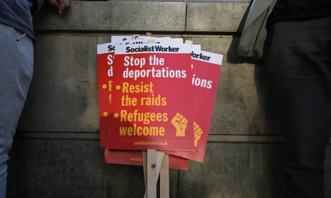 Placards saying: stop the deportations, resist the raids, refugees welcome.