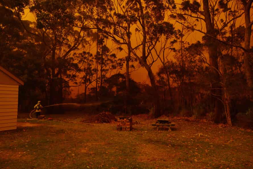 Firefighting crews battle a bushfire encroaching on properties near Lake Tabourie between Bateman’s Bay and Ulladulla south of Sydney.