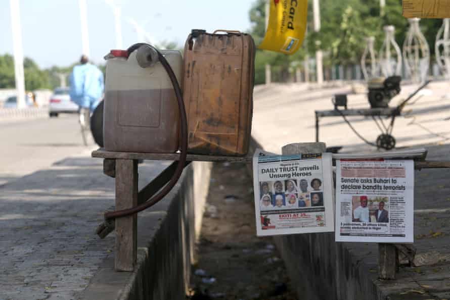 Petrol and newspapers for sale by a road in Maiduguri