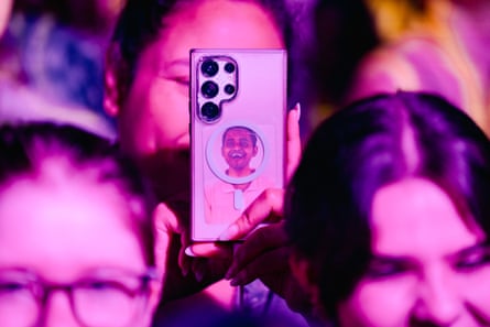 a person holds up their phone with a photo of a boy band member in the case